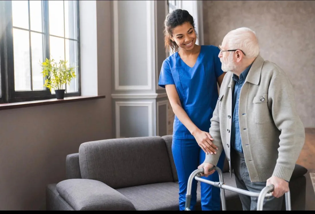Caregiver assisting an older adult with a walker at home